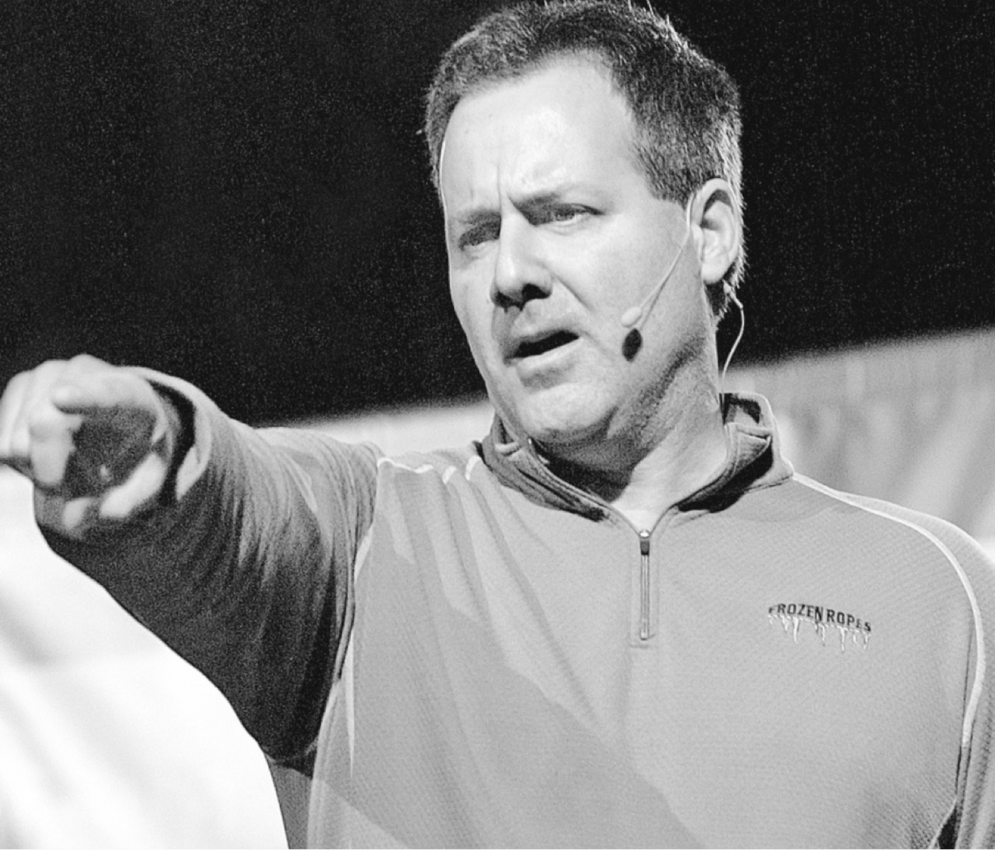 Tony Abbatine speaking on stage with a headset microphone